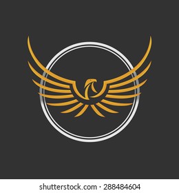 Eagle Logo Icon Design. Stock vector. Eagle Logo Icon Design. Stylized eagle spreads its wings. Golden and silver color on the dark background. 