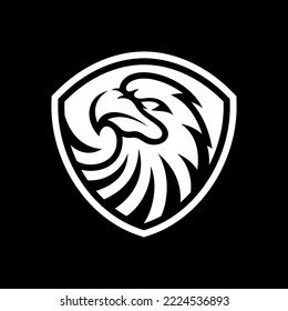 Eagle and shield logo design. Bird, falcon or hawk head badge emblem vector icon on dark background