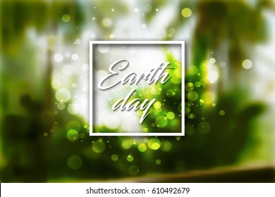 Earth day white text in square frame and bokeh light effect on green jungle forest blur background.