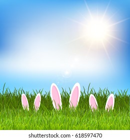 Easter background with bunny ears hiding in a grassy landscape