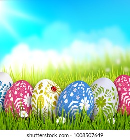 Easter background with colorful eggs with floral pattern in the grass