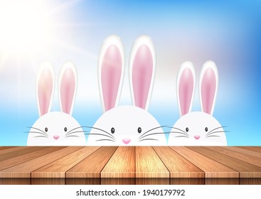 easter background with cute bunnies looking over a wooden table 