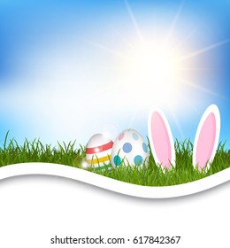 Easter background with eggs and bunny ears in grassy landscape
