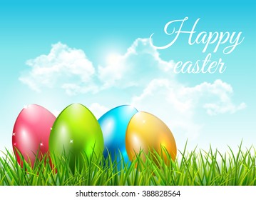 Easter background with eggs in grass and blue sky with clouds