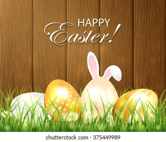 Easter background with golden eggs and rabbit ears in the grass on wooden background, illustration.