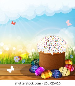 Easter bread and painted eggs on a wooden table. Butterflies fly over the grass. Happy Easter scene