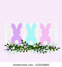 Easter bunnies in flowers near the fence