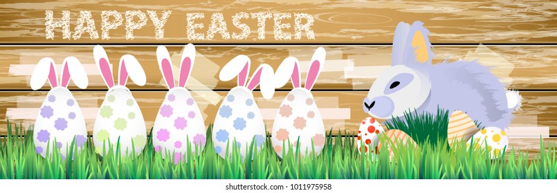 Easter. Easter bunnies in the grass on a wooden fence background. with Easter eggs. happy easter eggs. horizontal sheet orientation