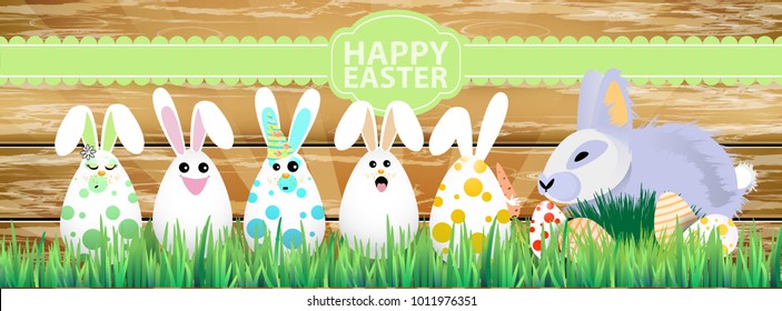 Easter. Easter bunnies in the grass on a wooden fence background. with Easter eggs. Happy Easter. Funny eggs with lashes and ears. horizontal sheet orientation