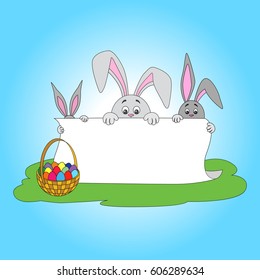 Easter bunnies holding white poster for congratulations on a religious holiday and a straw basket with colored eggs