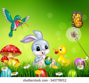 Easter bunny with decorated Easter eggs in a field