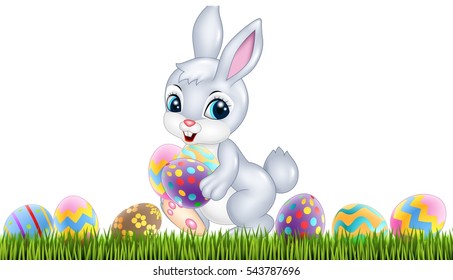 Easter bunny with decorated Easter eggs in a field