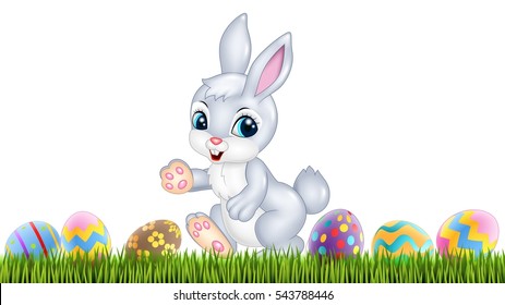 Easter bunny with decorated Easter eggs in a field