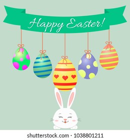 Easter bunny, green ribbon and Easter eggs. Congratulations Happy Easter.