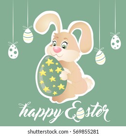 Easter bunny holding green egg with stars