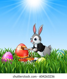 Easter bunny painting easter eggs in the grass background.Vector illustration