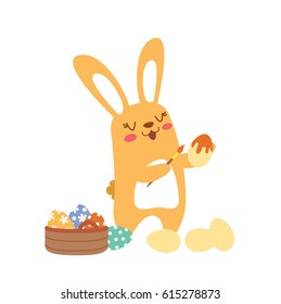 A Easter Bunny painting on eggs.