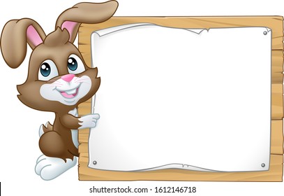 The Easter Bunny Rabbit peeking around a sign background and pointing at it.