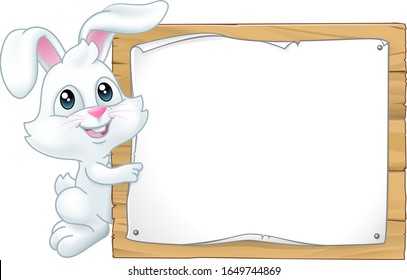 The Easter Bunny Rabbit peeking around a sign background and pointing at it.