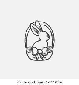 Easter bunny sitting in basket sketch icon for web, mobile and infographics. Hand drawn vector isolated icon.