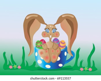 Easter bunny sitting in a cup with decorated eggs