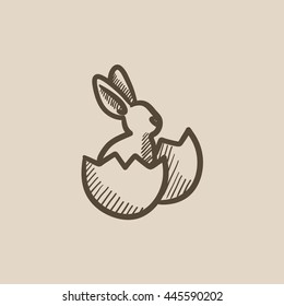 Easter bunny sitting in egg shell vector sketch icon isolated on background. Hand drawn Easter bunny sitting in egg shell icon. Easter bunny in egg shell sketch icon for infographic, website or app.