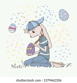 Easter bunny sitting in the grass with brush and eggs on the abstract background