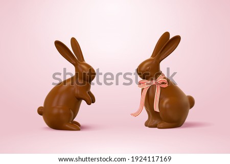Easter chocolate rabbits, one with ribbon bow and one without. 3d holiday elements isolated on pink background.