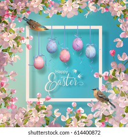 Easter decorative frame with the blooming spring branches, hanging painted eggs and birds