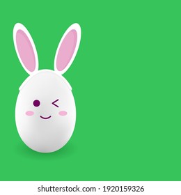 Easter egg with bunny ears on green background for advertising