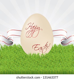 Easter egg with white/red ribbon in grass