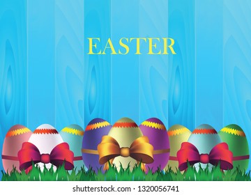 сolorful Easter eggs with a  bow on a wooden background of fresh green grass