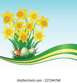Easter eggs, daffodils, grass and blue sky