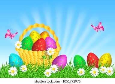Easter eggs with decorative golden ornament on green grass and basket against blue sky
