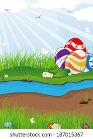 Easter eggs in the grass near the creek. Easter landscape