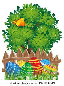 Easter eggs in the grass under a tree with bird