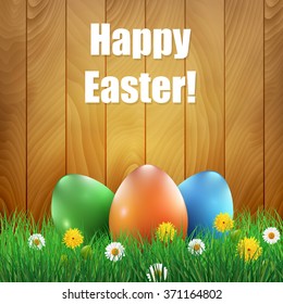 Easter eggs and grass with a wooden background. Ester greeting card.