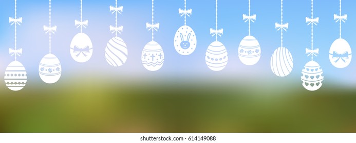 Easter eggs are hanging on the blurred background