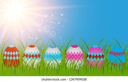 Easter eggs on the green grass. Seasonal holidays in April. Colorful egg and flowers.Banner