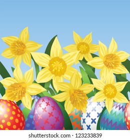 Easter eggs on meadow with daffodils