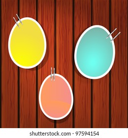 Easter eggs on pins on the wooden wall