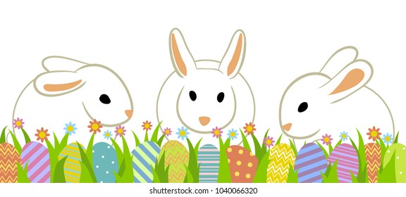 Easter eggs and three rabbits in grass isolated on white.