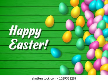 Easter frame with shiny colorful eggs spread over wooden background