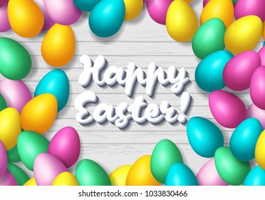 Easter frame with shiny colorful eggs spread over wooden background