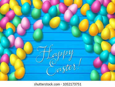 Easter frame with shiny colorful eggs spread over wooden background