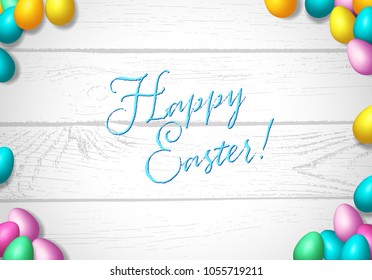 Easter frame with shiny colorful eggs spread over wooden background