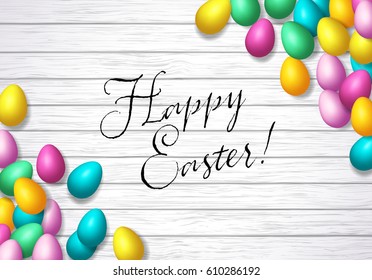 Easter frame with shiny colorful eggs spread over wooden background