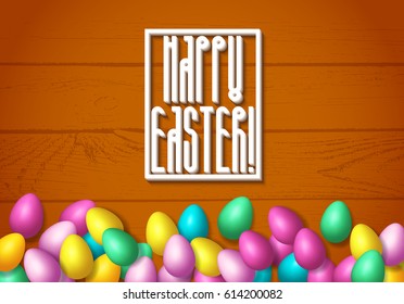 Easter frame with shiny colorful eggs spread over wooden background