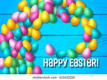 Easter frame with shiny colorful eggs spread over wooden background