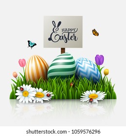 Easter greeting card with colorful eggs and flowers in the grass